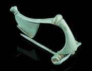 A LARGE ROMAN BRONZE STRONGLY PROFILED BROOCH 
Circa 2nd-3rd century AD.
A so-called 'Kräftig Profilierte Fibel'. The foot terminates in a large protr...
