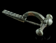 A LATE ROMAN BRONZE CROSSBOW BROOCH
Circa 4th century AD.
With arched bow and onion-shaped terminals ('Zwiebelknöpfe'). The top of the bow is decorate...