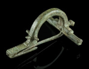 A ROMAN BRONZE EARLY CROSSBOW BROOCH
Circa 3rd century AD.
So-called 'Scharnierarmfibel', a precursor of the classical crossbow brooch. With arched bo...