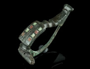 A ROMAN ENAMELLED BRONZE BROOCH
Circa late 1st-2nd century AD.
With a profiled foot, an enamelled bow (a series of small squares with red and green en...