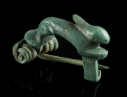 A ROMAN BRONZE HARE BROOCH
Circa 2nd-3rd century AD.
Knee brooch with small semicircular headplate, modelled three-dimensional in the shape of a hare....