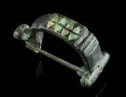 A ROMAN ENAMELLED BRONZE BROOCH
Circa late 1st-2nd century AD.
With a short foot and an enamelled bow (a series of small triangles with red and blue e...