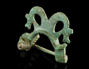 A LATER ROMAN EQUAL-ENDED BRONZE BROOCH WITH HORSE HEADS
Circa 4th century AD.
Equal-ended bow brooch with two stylised horse heads. The manes are ind...