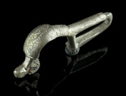 A BYZANTINE SILVER BROOCH WITH BENT FOOT
Circa 6th-7th century AD.
Cast bow brooch with folded foot ('umgeschlagenem Fuß'); incised and punched decora...
