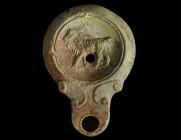 A ROMAN TERRACOTTA OIL LAMP WITH A GOAT
Circa 1st-2nd century AD.
Oil lamp with rounded body, concave discus, and round voluted nozzle; the discus is ...