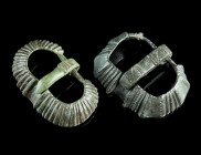 TWO LATE ANTIQUE BRONZE BELT BUCKLES
Circa 4th-6th century AD.
Two belt buckles with a ridged design. Thorns ancient but probably not belonging.
L 42 ...