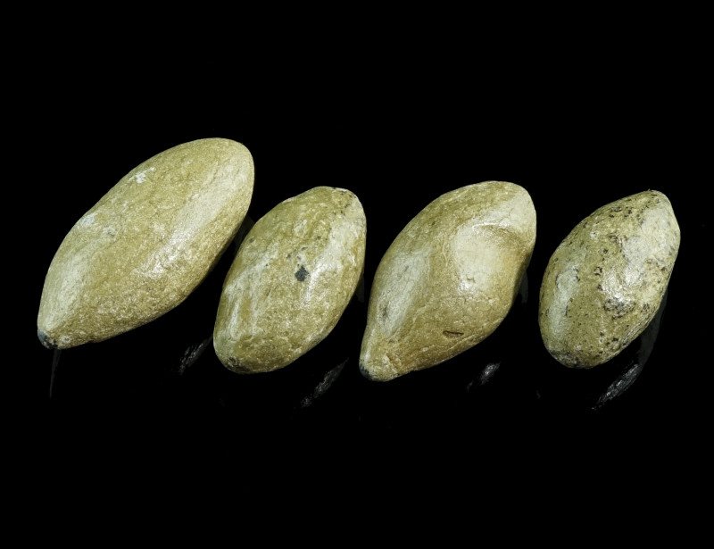 A GROUP OF FOUR GREEK/ROMAN LEAD SLING-SHOTS 
Circa 3rd century BC - 1st century...