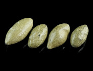 A GROUP OF FOUR GREEK/ROMAN LEAD SLING-SHOTS 
Circa 3rd century BC - 1st century AD.
Almond shaped sling bullets of different size. 
L 24-33 mm Ex Eur...