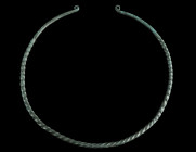 A EUROPEAN LATE BRONZE AGE TWISTED TORQUE
Circa 1000-800 BC.
Twisted hoop of solid bronze, the plain tapering ends with flattened coiled terminals.
Di...