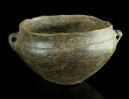 AN URNFIELD CULTURE CERAMIC BOWL
Circa 1300-800 BC.
Bowl with flat base and two pierced lug handles. An incised line along the shoulder. Minor damage ...