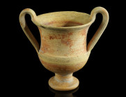 A WESTERN GREEK TERRACOTTA KANTHAROS
Circa 4th-3rd century BC.
With an offset base and two high arched handles. Remains of an orange-red slip on the o...