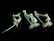 A GROUP OF THREE ROMAN BRONZE BROOCHES
Circa 2nd-3rd century AD.
Two strongly profiled brooches with spring and pin, and a knee brooch with hinged pin...