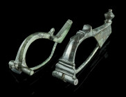 TWO ROMAN BRONZE BROOCHES
Circa 2nd-3rd century AD.
An early crossbow brooch, and a wolf head bow brooch. Both with hinged pin.
L 64 mm, and L 66 mm E...
