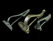 A GROUP OF THREE ANCIENT BRONZE BROOCHES
Circa 1st century BC - early 2nd century AD.
A late Iron Age/La Tène brooch with open catch plate, and two ea...