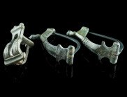 A GROUP OF THREE ROMAN BRONZE BROOCHES
Circa 2nd-3rd century AD.
Two bow brooches, and a double knee brooch with notched decoration. All hinged, pins ...