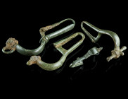 A GROUP OF FOUR BYZANTINE BRONZE BROOCHES WITH BENT FOOT
Circa 5th-7th century AD.
Bow brooches with folded foot (umgeschlagenem Fuß), with incised (o...