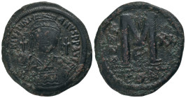 JUSTINIAN I.(527-565).Constantinople.Follis.
Obv : D N IVSTINIANVS P P AVC.
Helmeted, cuirassed bust facing, holding cross on globe and shield with ...
