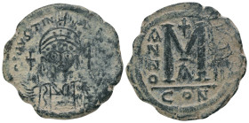 JUSTINIAN I.(527-565).Constantinople.Follis.
Obv : D N IVSTINIANVS P P AVC.
Helmeted, cuirassed bust facing, holding cross on globe and shield with ...