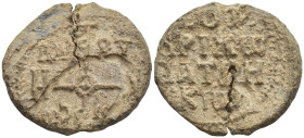 Byzantine Lead Seal, (25mm, 14,8 g) Cruciform monogram. / Legends in four lines.