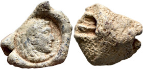 Anonymous, 3rd century. Seal (Lead, 19 mm, 7.86 g). Head of Hercules to right, wearing lion skin headdress. Rev. Textile imprint. Bertolami Fine Arts,...