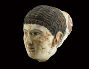 Egyptian Polychrome Face Mask
Roman Period, 30 BC-323 AD. A female gesso face mask with wavy hair and a fringe of curls, applied black pigment detail...