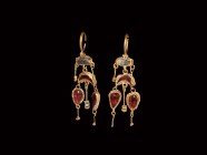 Parthian Gold Earring Pair
3rd-1st century BC. An elaborate matched pair of gold earrings, each a penannular hoop with hinged dangle, rectangular cel...