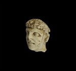 Roman Limestone Head
2nd-3rd century AD. A carved limestone male head with short tousled hair, wreath to the brow with central rosette, large doleful...