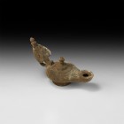 Roman Oil Lamp
1st-3rd century AD. A bronze oil lamp with biconvex piriform body and flared base, tapering nozzle with segmented face and flared rim,...