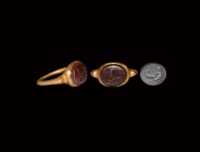 Roman Gold Ring with Pan Gemstone
2nd century AD. A carnelian intaglio of the god Pan mounting a goat, set in a gold finger ring with keeled hoop and...