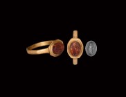 Roman Gold Ring with Cupid Gemstone
2nd century AD. A gold finger ring comprising an octagonal D-section hoop, flared bezel with inset carnelian cloi...