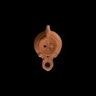 Roman Oil Lamp with Stag
1st-2nd century AD. A terracotta oil lamp with broad shoulder, volute scroll above the nozzle, lug handle, discus with low-r...