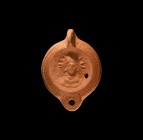 Roman Oil Lamp with Head of Sol
2nd-3rd century AD. A terracotta oil lamp with lug handle to the rear, discus with high-relief facing mask of Sol. 12...