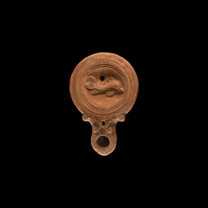Roman Oil Lamp with Dolphin
2nd century AD. A ceramic oil lamp with rounded lon...