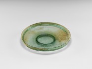 Roman Green Glass Footed Bowl
1st-2nd century AD. An aqua glass bowl with broad flan, basal ring and raised rim. 321 grams, 23.2cm (9 1/4"). Property...