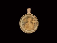 Byzantine Gold Saint in Glass Pendant
10th-12th century AD. An aqua glass discoid pendant with folded suspension loop, gold foil bust of a saint(?) w...