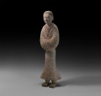 Chinese Han Servant Figure
Han Dynasty, 206 BC-220 AD. A ceramic figure of a courtly attendant with short hair, layered robes with V-shaped necklines...