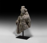 Gandharan Buddha Statue
1st-4th century AD. A carved schist figure of the youthful Buddha standing with draped mantle and swags of beads, elaborate h...