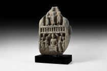 Gandharan Figural Frieze Section with Buddha
2nd-4th century AD. A carved schist frieze fragment with three robed standing female figures clasping ea...