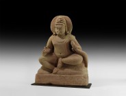 Indian Sitting Buddha
2nd millennium AD. A carved sandstone(?) figure of Buddha seated with legs folded in the single lotus position, fleshy body wit...