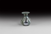 Islamic Glass Sprinkler Flask
10th-11th century AD. A green glass squat jar with five radiating ribbed flanges to the body, restricted neck, everted ...
