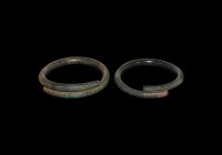 Bronze Age Decorated Bracelet Pair
2nd millennium BC. A pair of round-section bronze coiled bracelets comprising: one with bands of incised lines, th...