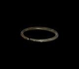 Bronze Age Arm-Ring
2nd millennium BC. A penannular bronze arm-ring tapering towards the butted ends. 219 grams, 12.9cm (5"). Property of a North Lon...