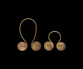 Bronze Age Gold Spectacle Pendant Pair
2nd millennium BC. A pair of two gold pendants formed as two coils with a loop between; on a custom-made stand...