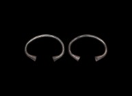 Iron Age Celtic Silver Bracelet Pair
2nd century BC-1st century AD. A matched pair of silver crescentic bracelets, each a round-section shank with ho...