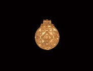 Viking Gold Filigree Pendant
10th-12th century AD. A gold disc pendant with applied filigree and granule cross flory motif with central boss, integra...