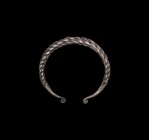 Viking Silver Plaited Bracelet
9th-11th century AD. A silver penannular bracelet formed from plaited rods, hammered terminals tapering to a scroll. 6...