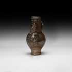 Post Medieval Bellarmine Jar
16th century AD. A mottled salt-glazed stoneware jug of bartmannskrug type with bulbous body, narrow tiered base, ribbed...
