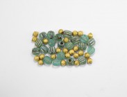 Parthian Glass Bead Group
1st-2nd century AD. A large group of iridescent green glass melon beads; with later gilt striated spacer beads. 150 grams t...