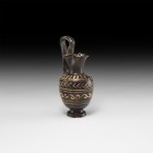 Greek Gnathian Trefoil-Mouth Oinochoe
5th-3rd century BC. A blackware oinochoe with barrel-shaped body, pedestal base, narrow neck with pinched trefo...