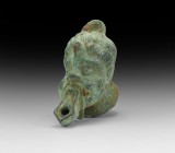 Roman Oil Lamp with Face
1st-2nd century AD. A bronze oil lamp with stepped base, body formed as a male head with filler hole above the crown, nozzle...